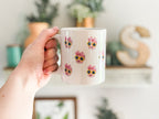 Person holding a mug with a baby's face multiplied around the mug in rows. Final product comes with images provided by customer. Shown in 11oz size.