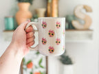 Person holding a mug with a baby's face multiplied around the mug in rows. Final product comes with images provided by customer. Shown in 15oz size.