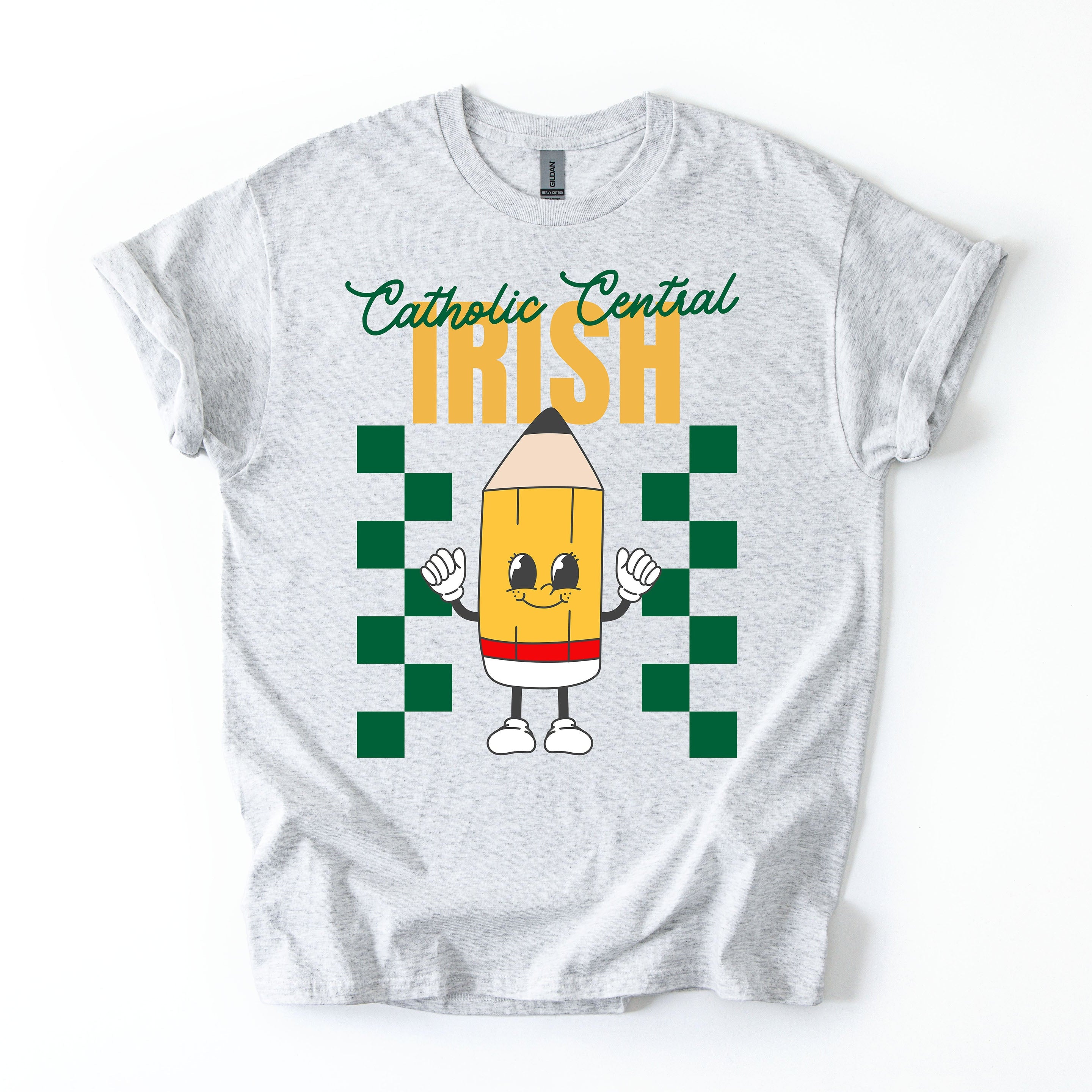 White t-shirt with a colorful design featuring a pencil character and text "Catholic Central Irish" on a white background